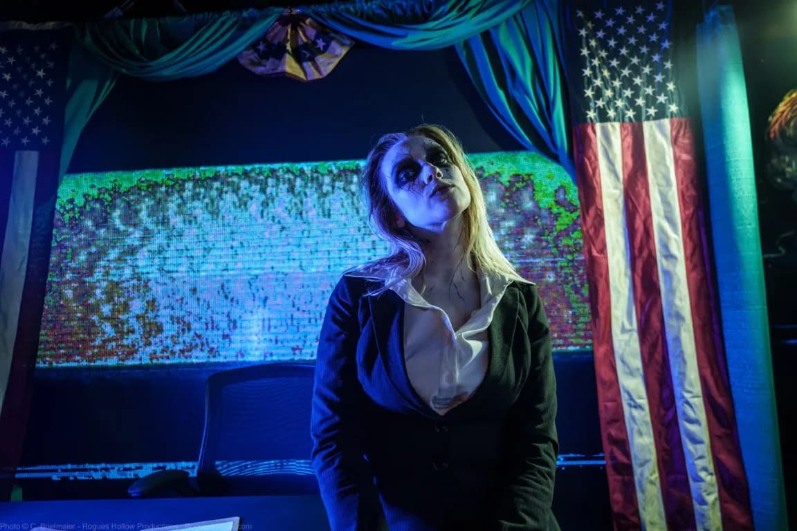 A haunted house actor in pale make-up and a suit, sitting on a bench and staring at the ceiling.