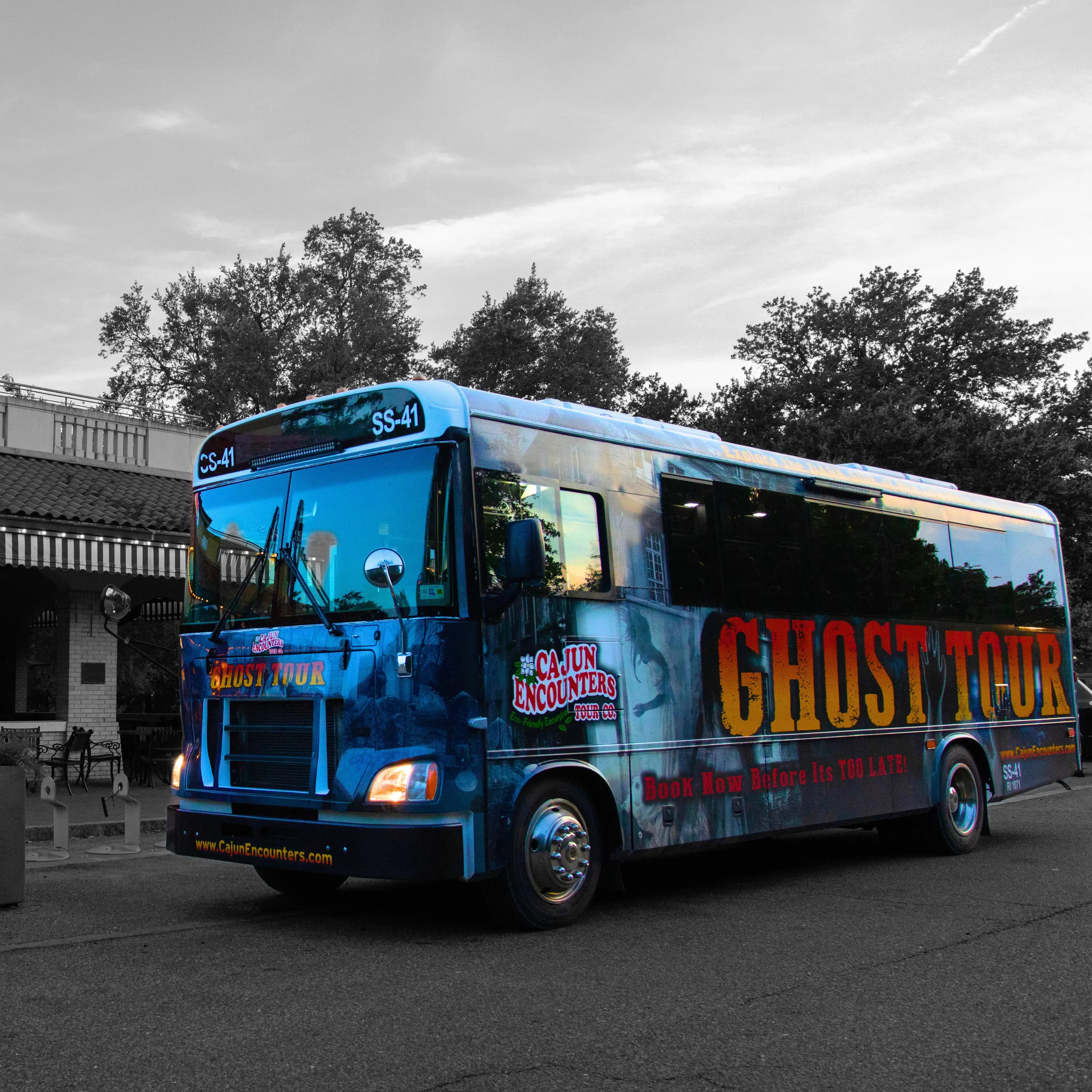 Decorated bus for a cajun encounters ghost tour in New Orleans, featuring eerie graphics and promotional text.