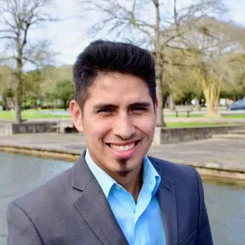 A man in a suit smiling at the camera.