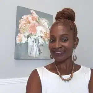 A woman standing in front of a painting of flowers.