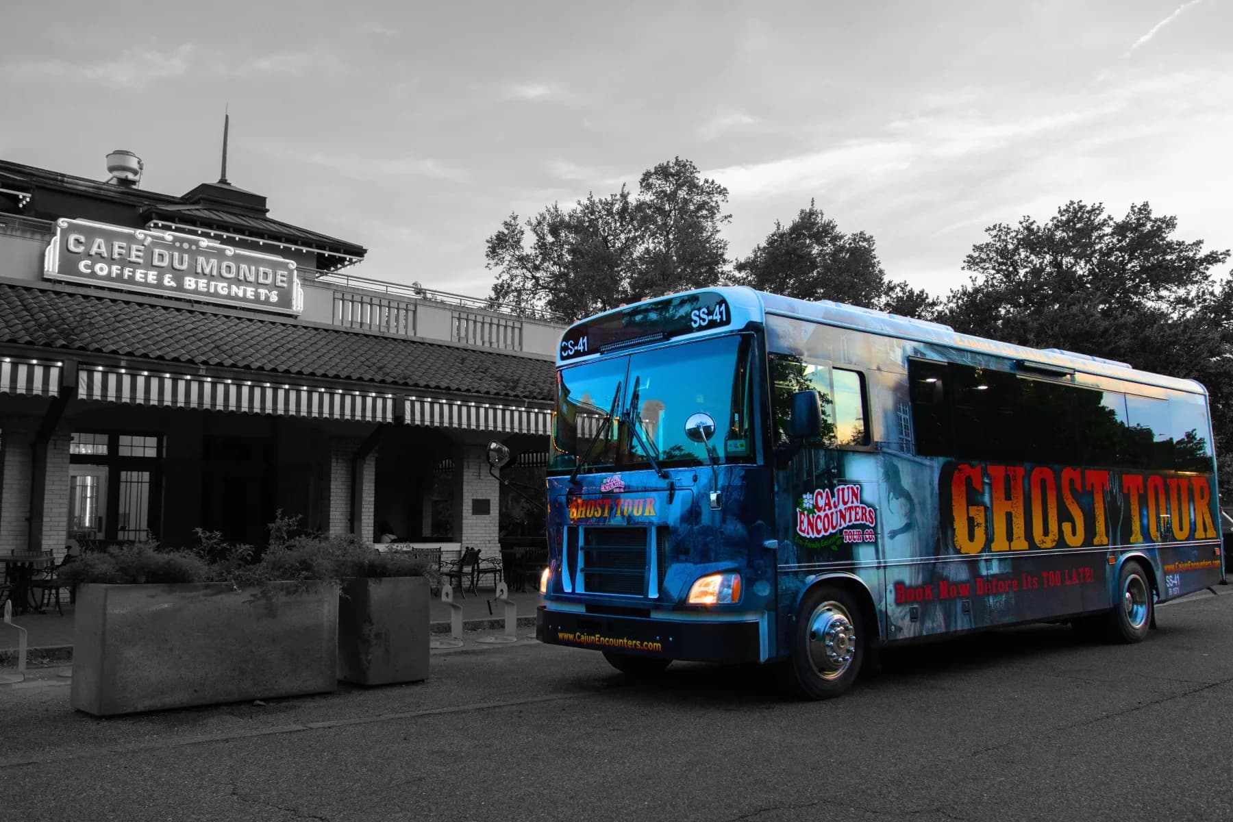 Cajun Encounters ghost bus parked outside Cafe du Monde — haunted New Orleans night tour
