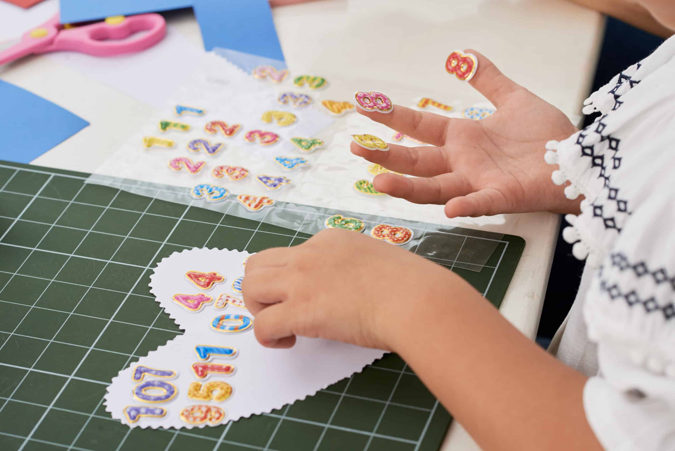 A girl places stickers on a paper heart while participating in kid friendly activities in New Orleans