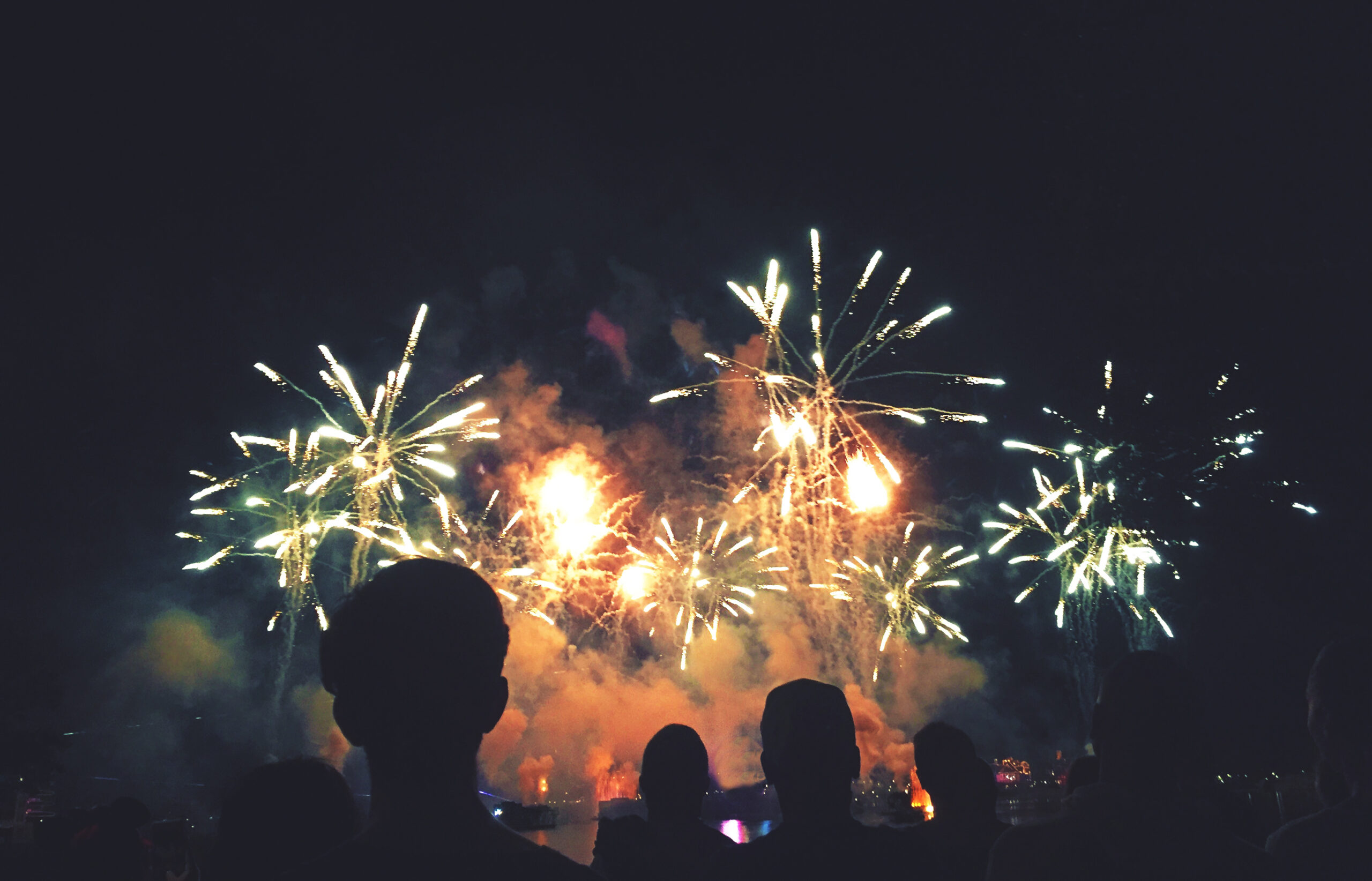 An audience watches fireworks above the Mississippi River during New Year's Eve in New Orleans